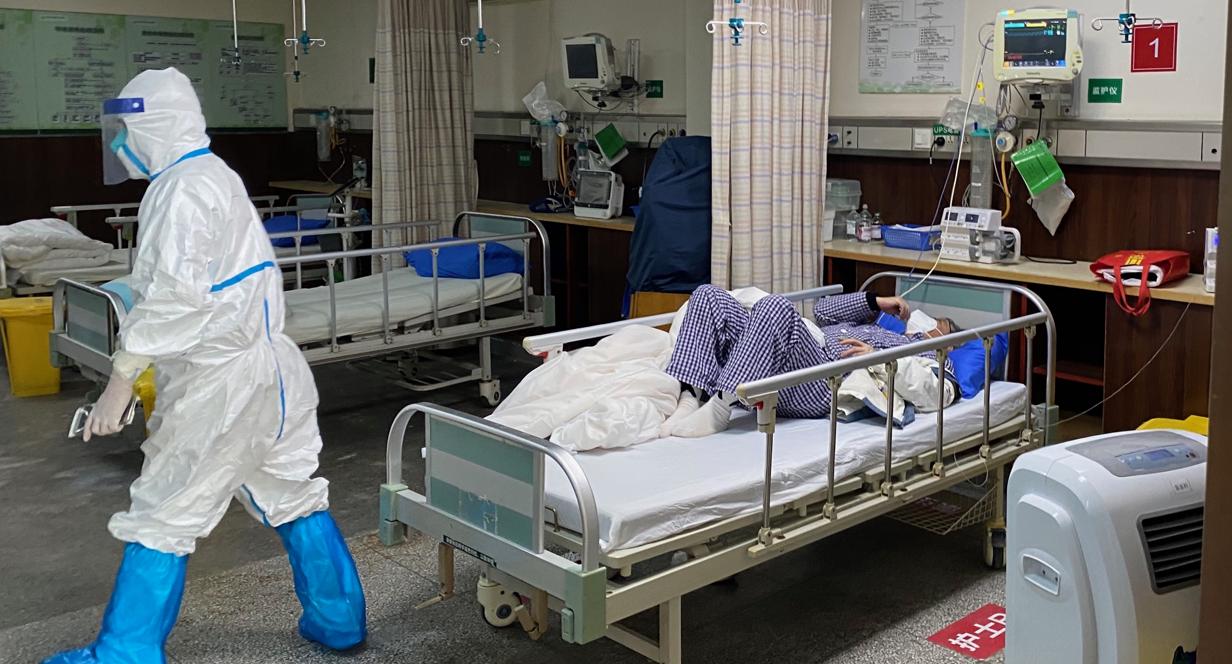 Protegido con un traje especial, un enfermero atiende a un paciente del coronavirus en el Hospital Número 7 de Wuhan