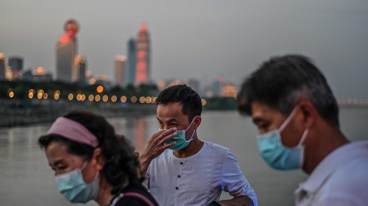 Grupo de chinos con mascarilla, en Wuhan