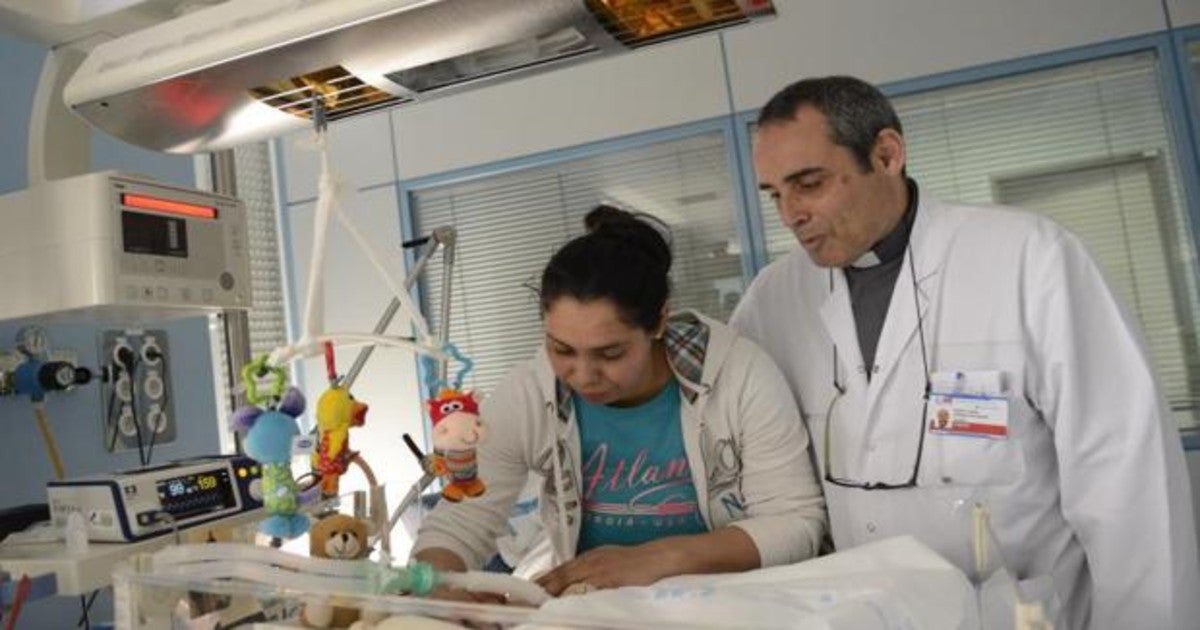 Un capellán junto a una madre que cuida de su hija en el hospital Clínico