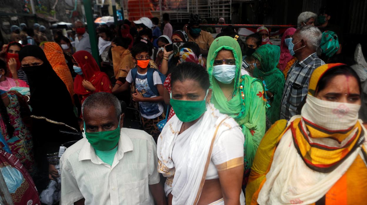 La gente espera ser evacuada de un barrio marginal cercano a la costa en Bombay por el ciclón