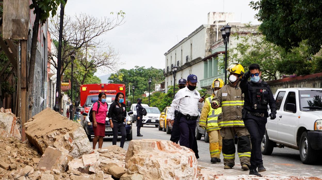 Miembros de la policía y de los bomberos observan los daños en la ciudad de Oaxaca (México)