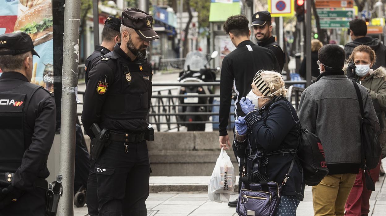 Un policía llama la atención el pasado mes de abril a una mujer en el barrio madrileño de Vallecas