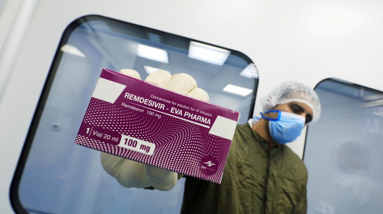 Un trabajador del laboratorio muestra a la cámara una caja del fármaco Remdesivir