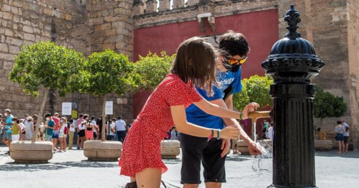 Un pareja se refresca junto a los Reales Alcázares (Sevilla)