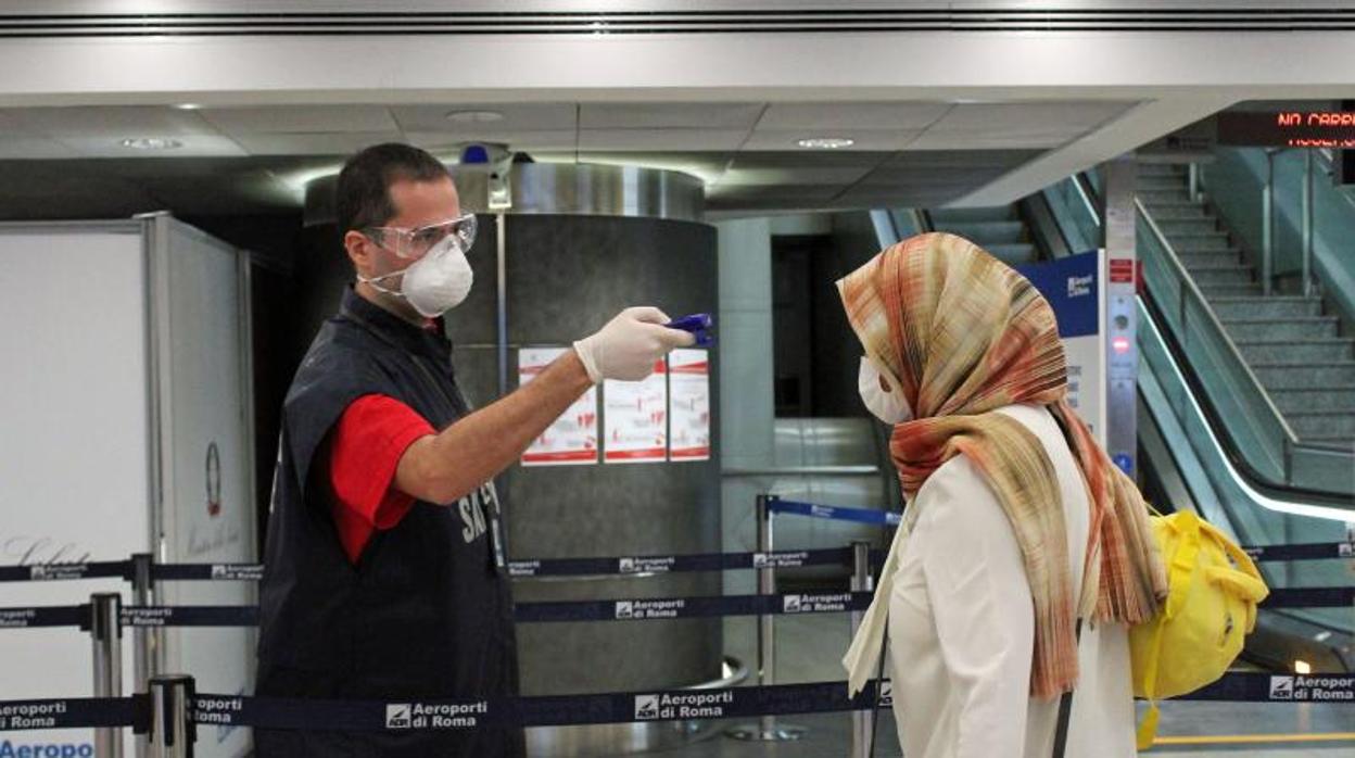 Una mujer pasa un control de temperatura en el aeropuerto Leonardo da Vinci en Fiumicino