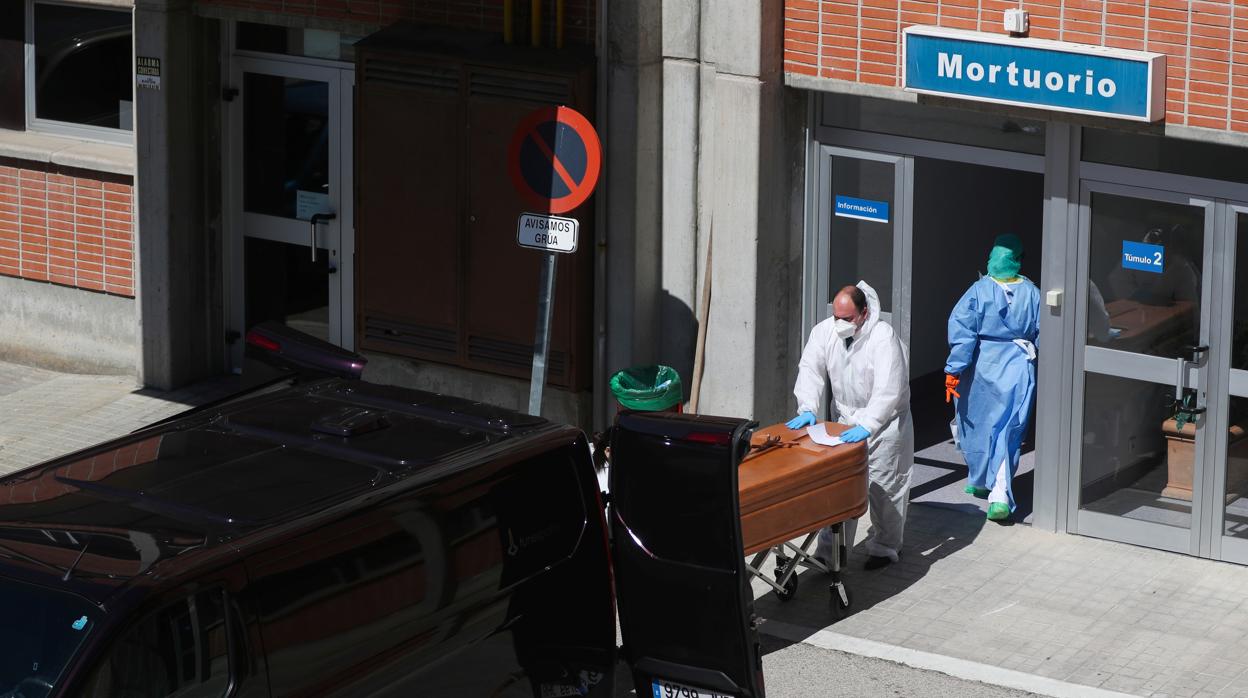 El operario de una funeraria traslada los cadáveres de personas fallecidas por Covid de la morgue del Hospital Severo Ochoa de Leganés (en Madrid)