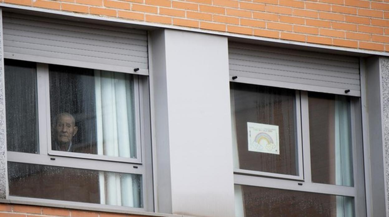 Un anciano mira por la ventana de una residencia en Madrid