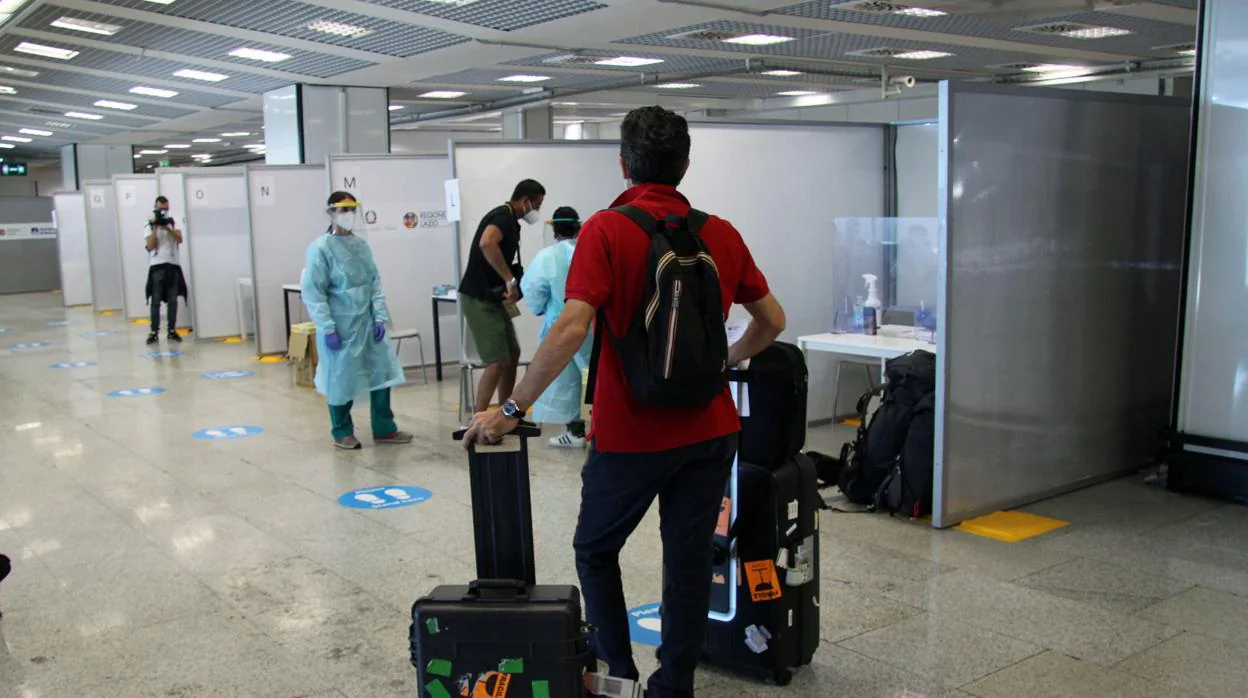Varios pasajeros esperan para hacerse un test rápido en el aeropuerto de Fiumicino, en Roma/ La pandemia obliga al sector aéreo a reinventarse