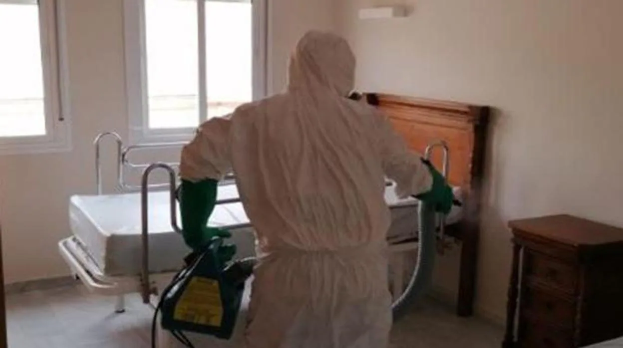 Un operario desinfecta una habitación de una residencia