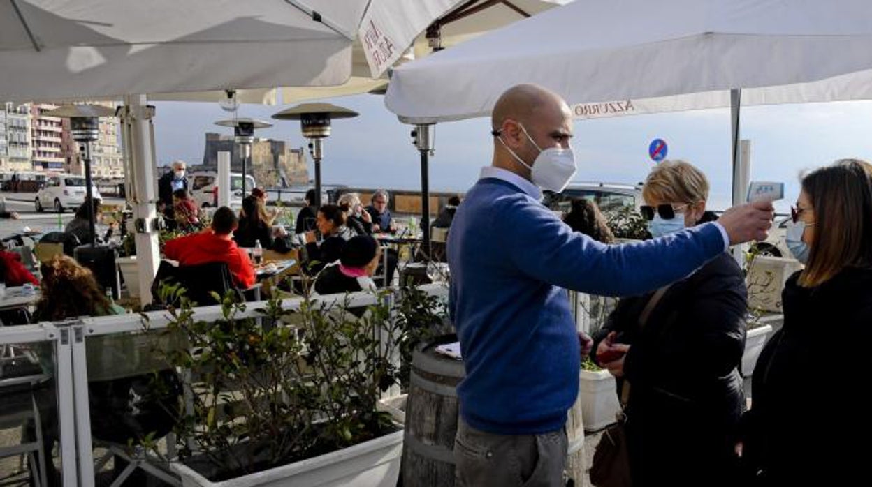 Un hombre toma la temperatura a dos mujeres