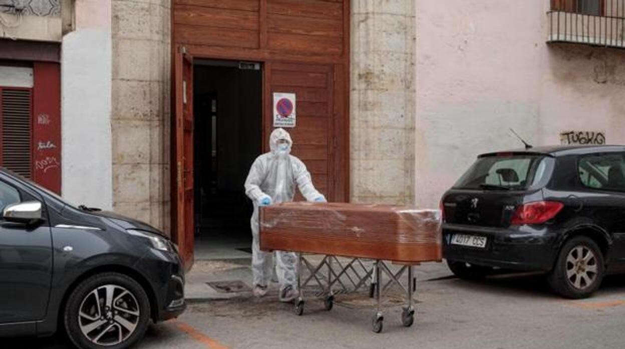 Un operario de funeraria retira el cadáver de un anciano fallecido en una residencia valenciana
