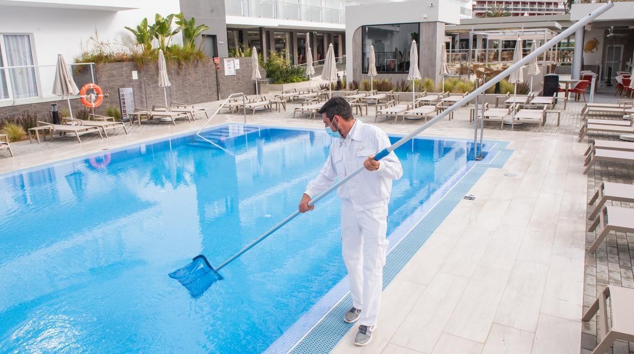 El operario de mantenimiento del hotel RIU Concordia prepara la piscina ante la llegada de los turistas alemanes