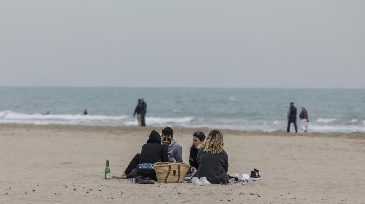 Un grupo de jóvenes sin mascarilla en la playa la Malvarrosa en Valencia
