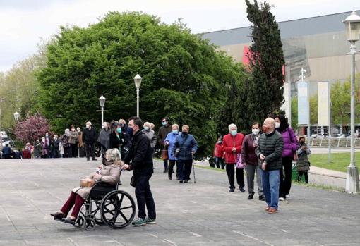 Numerosas personas hacen cola para vacunarse contra el Covid 19 en el centro de vacunación instalado en el Palacio de Deportes de Gijón