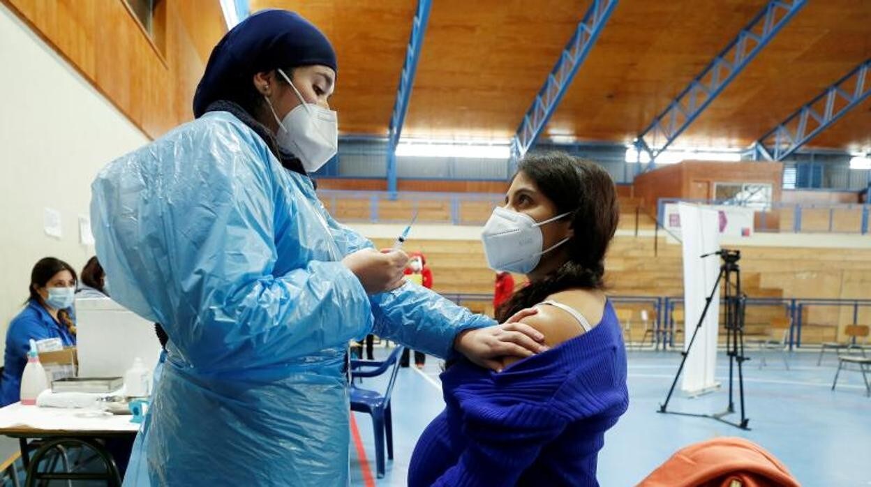 Una embarazada recibe la vacuna de Pfizer en Chile