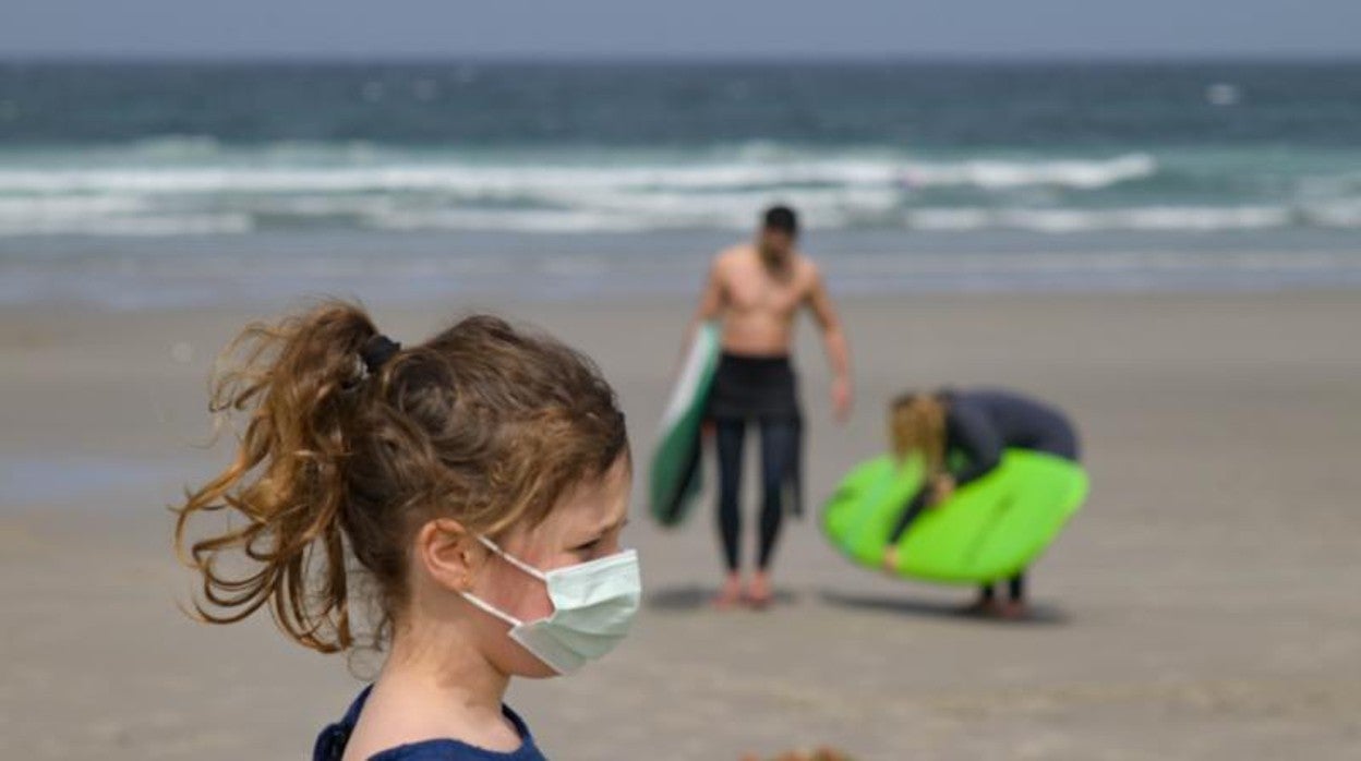 Una niña lleva mascarilla en la playa das Salseiras