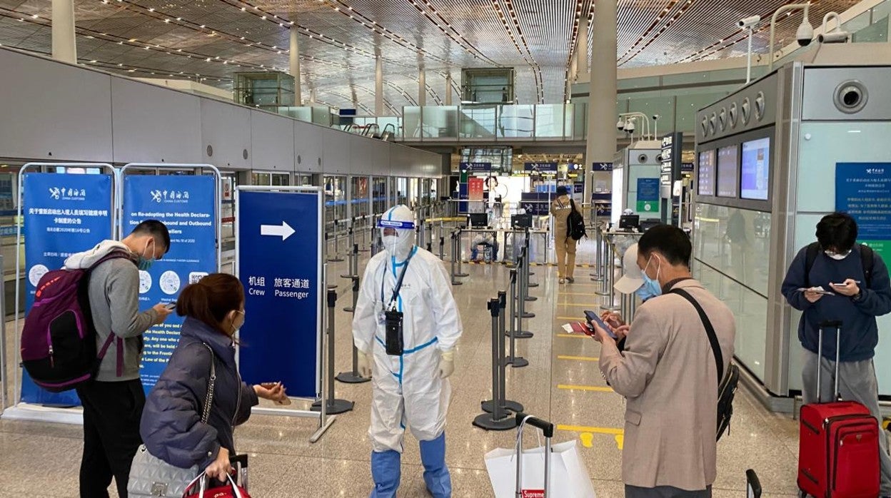 Estrictos controles de seguridad y personal con trajes de protección en la terminal internacional del aeropuerto de Pekín para prevenir el coronavirus