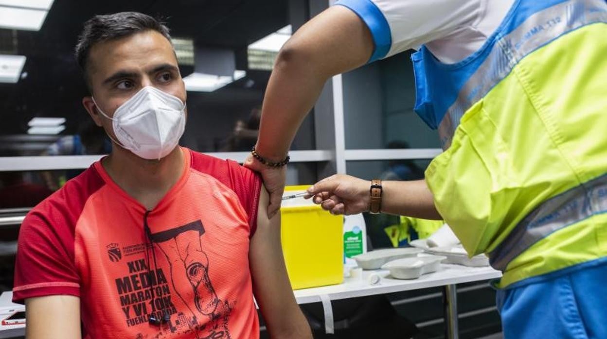 Un sanitario administra una dosis de la vacuna de Pfizer a un hombre en el Wizink Center en Madrid