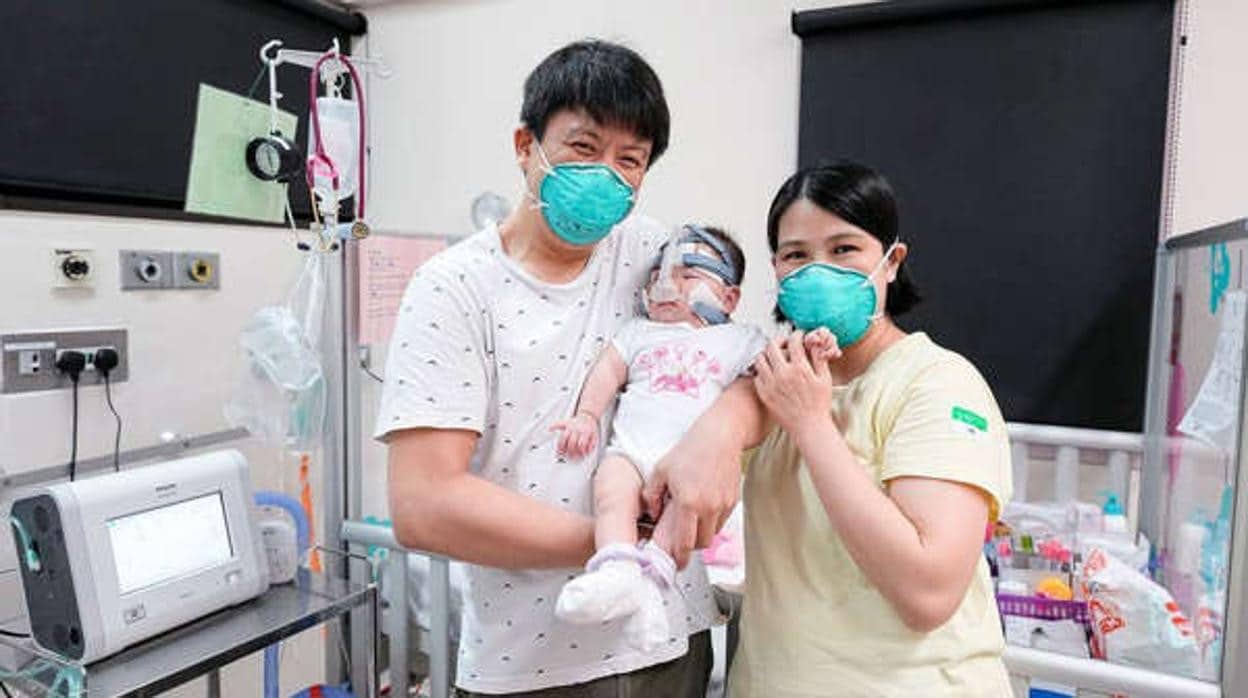 El bebé Kwek Yu Xuan con sus padres en el momento del alta