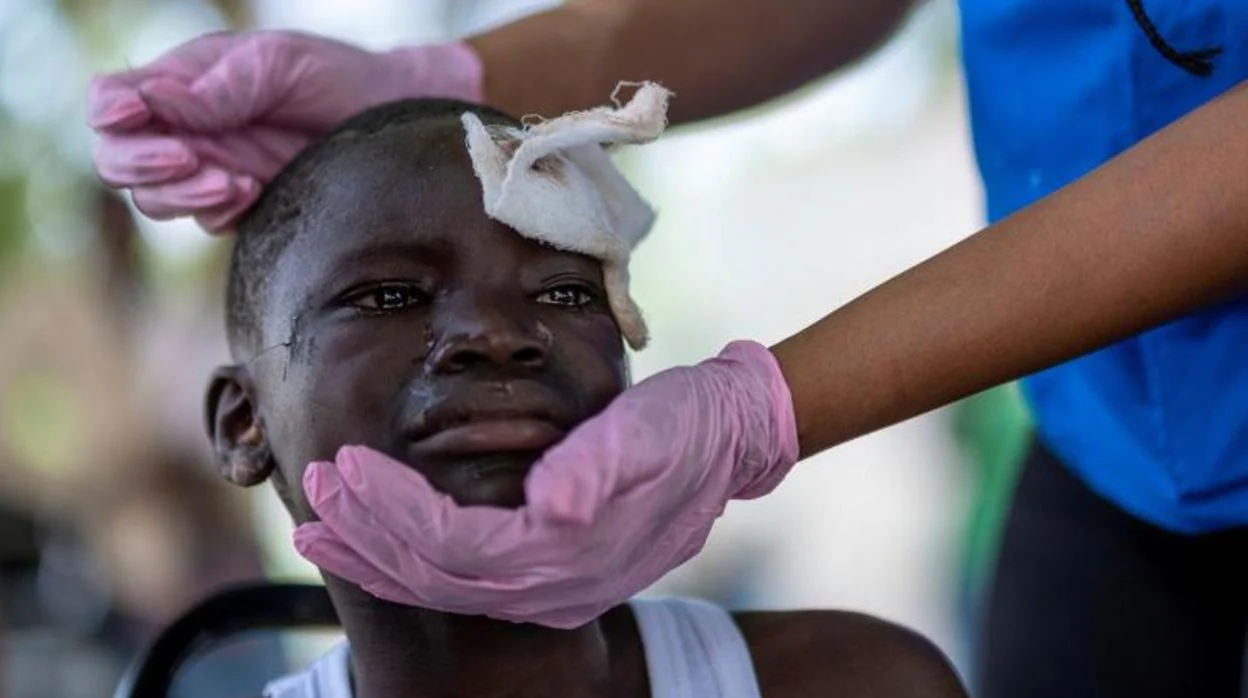 Una sanitaria cura a un niño herido tras el terremoto de Haití