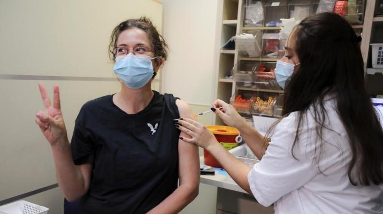 Una mujer posa para una foto al recibir la tercera dosis de la vacuna contra el Covid-19