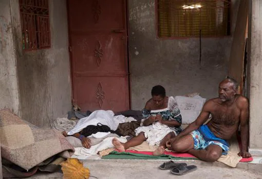 Noel (derecha) y su familia descansan en la entrada de su casa, en Les Cayes (Haití), tras el terremoto registrado el sábado pasado