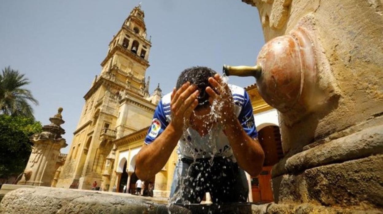 Un turista se refresca en el centro de Córdoba durante la ola de calo