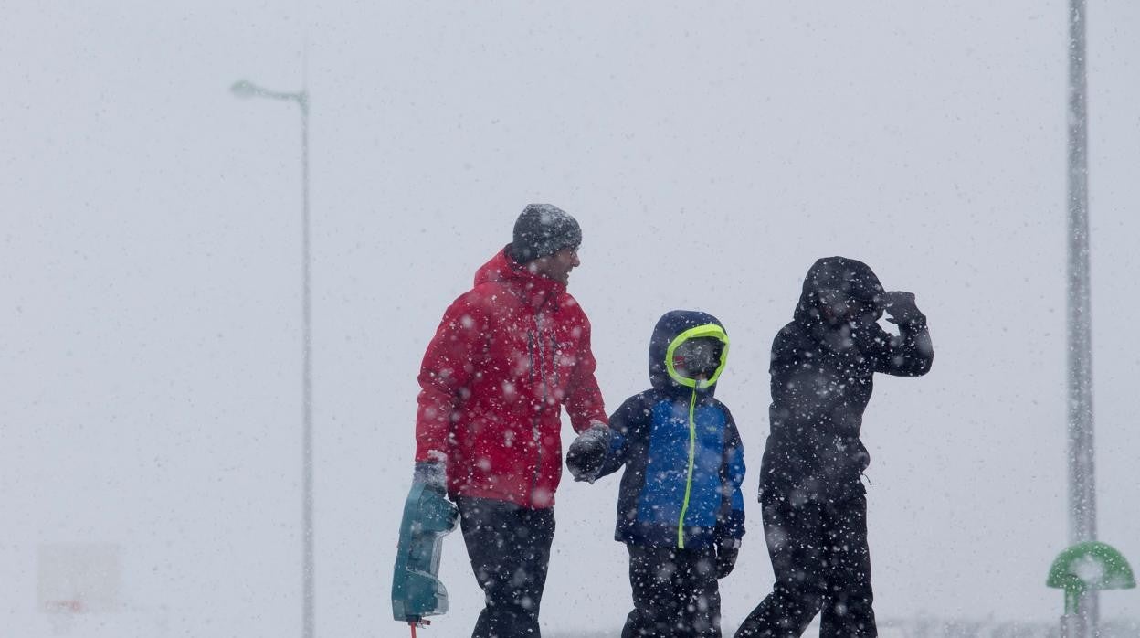 Tres personas caminan por una vía nevada, a 8 de diciembre de 2021, en Lugo, Galicia,