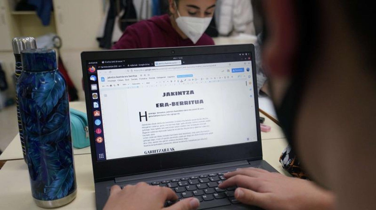 Un joven realiza un trabajo en clase en euskera
