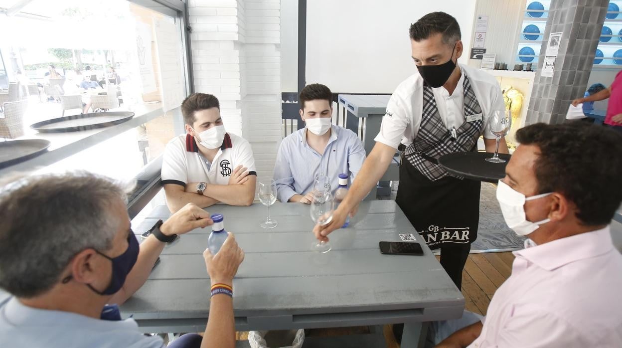 Un grupo de personas con mascarilla en el interior de un restaurante