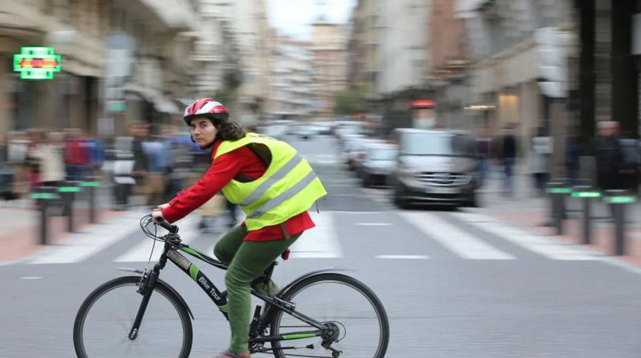 Una transeunte pasea por Bilbao en bicicleta