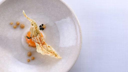 Tartare de calamar con yema de huevo líquida, consomé de cebolla y un aceite hecho con las hojas de lima kaffir, un plato del restaurante Lasarte