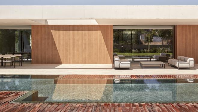 Tras el agua se aprencian los dos porches, en uno incide el sol en invierno y en el otro en verano