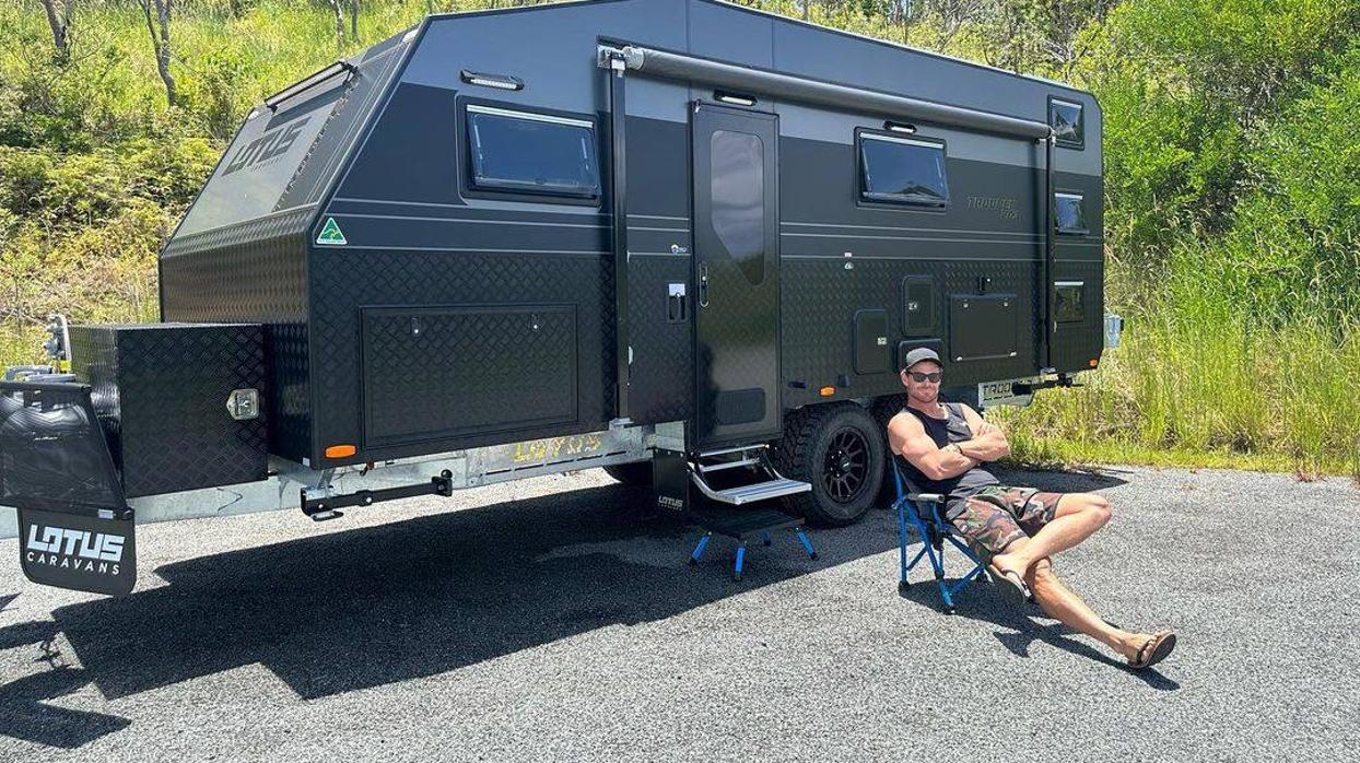El actor Chris Hemsworth posa delante de su autocaravana.