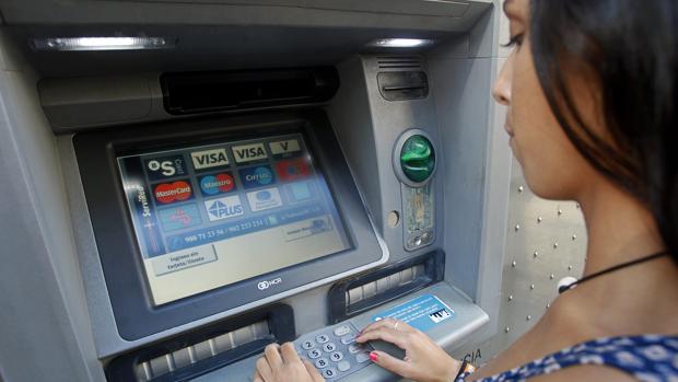 Una joven accede a su cuenta para sacar dinero desde un cajero automático