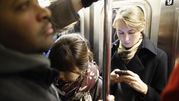 Una mujer, con su móvil, en el metro de Nueva York