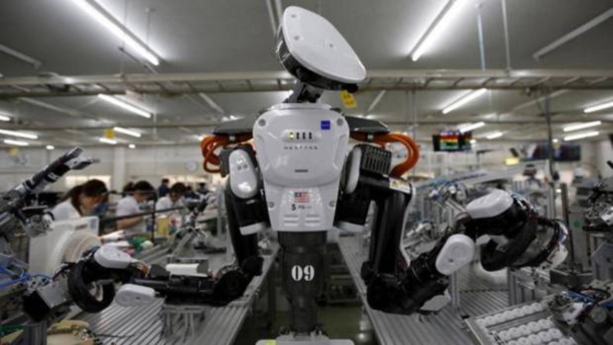 Un robot trabaja con humanos en una fábrica