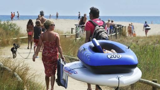 Un grupo de veraneantes se dirigen a la playa frente a un popular camping de Sant Pere Pescador