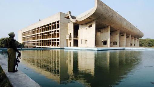 Un policía hindú parado delante del Assambly Building de Le Corbusier., en Chandigarh, India