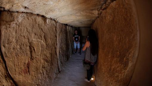 Una mujer toma una foto dentro de uno de los dólmenes de Antequera