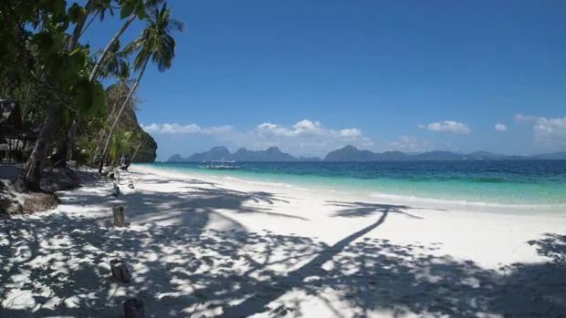Filipinas es un excelente destino para descansar en una playa de arena blanca con exóticas palmeras y agua en distintos tonos de azul. En la imagen, Entalula Island Beach Area, en El Nido