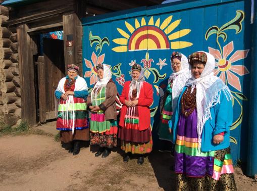 Un grupo de mujeres de Desyatnikovo, vestidas con los trajes tradicionales, esperan a los visitantes para enseñarles sus costumbres y canciones