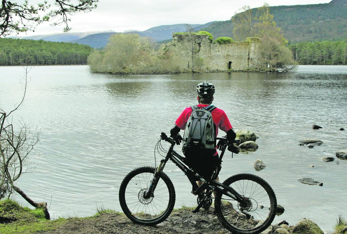 Un ciclista disfruta de la vista del Loch an Eilein, lago situado en Aviemore, en el corazón del Parque Nacional de Cairngorms (Escocia)