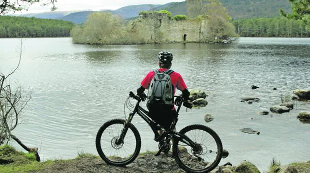 Un ciclista disfruta de la vista del Loch an Eilein, lago situado en Aviemore, en el corazón del Parque Nacional de Cairngorms (Escocia)