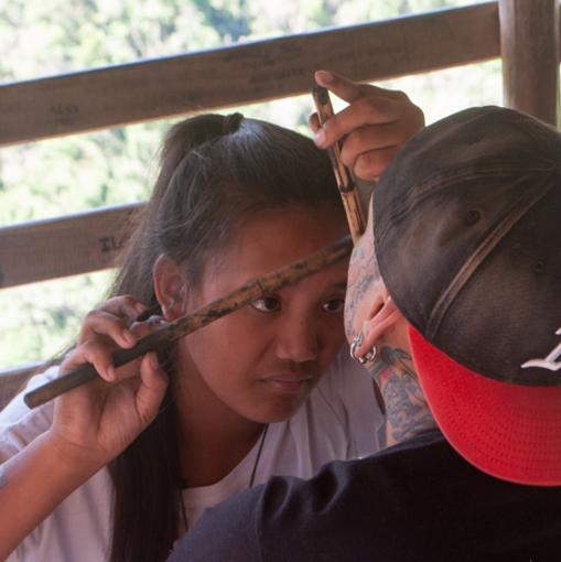 Grace Palicas, nieta de Whang-Od, haciendo un tatuaje facial