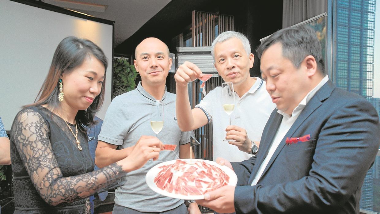 Clientes chinos degustan jamón ibérico en una cena en el hotel Gran Hyatt de Cantón (Guangzhou), elaborada por Alexandre Mazzia (abajo, con camisa negra), chef francés con estrella Michelin
