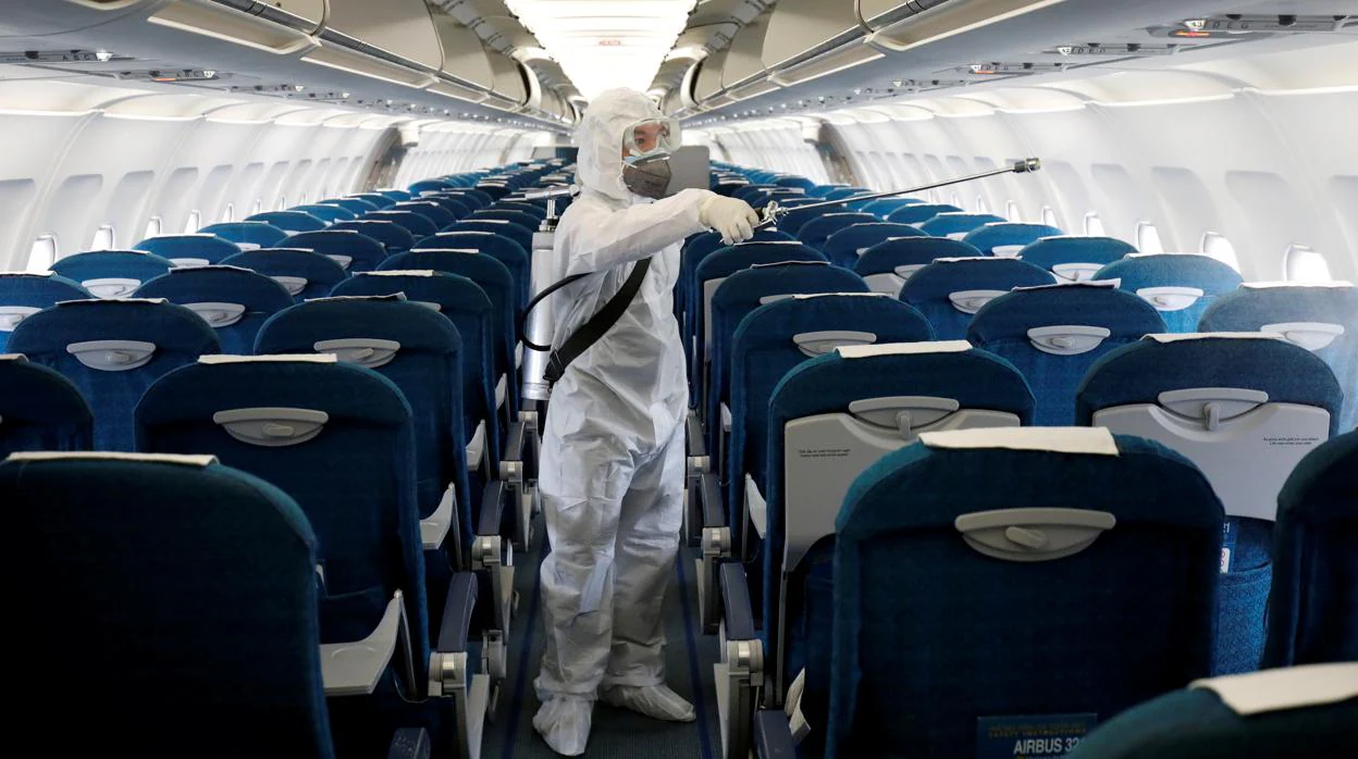 Un empleado de seguridad limpia un avión en el aeropuerto de Hanoi
