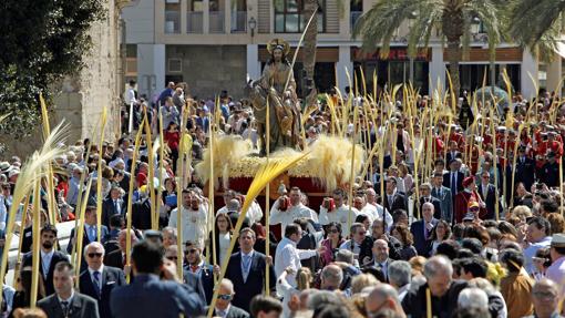 La imagen de "la burrita" rodeada de palmas blancas durante el recorrido oficial de la procesión del Domingo de Ramos en Elche, en 2019