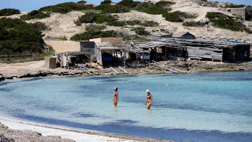 Dos personas se bañan en la playa de ses Illetes este lunes 4 de mayo