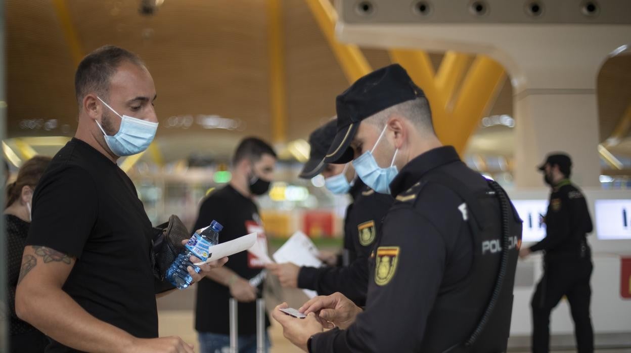 Un policía hace unas comprobaciones en el aeropuerto a un turista